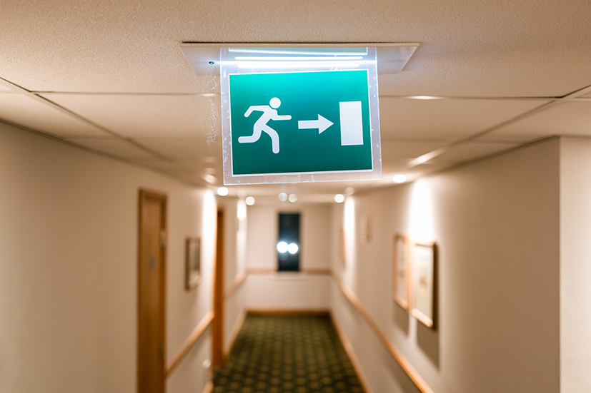 Image of emergency exit sign in office building corridor 